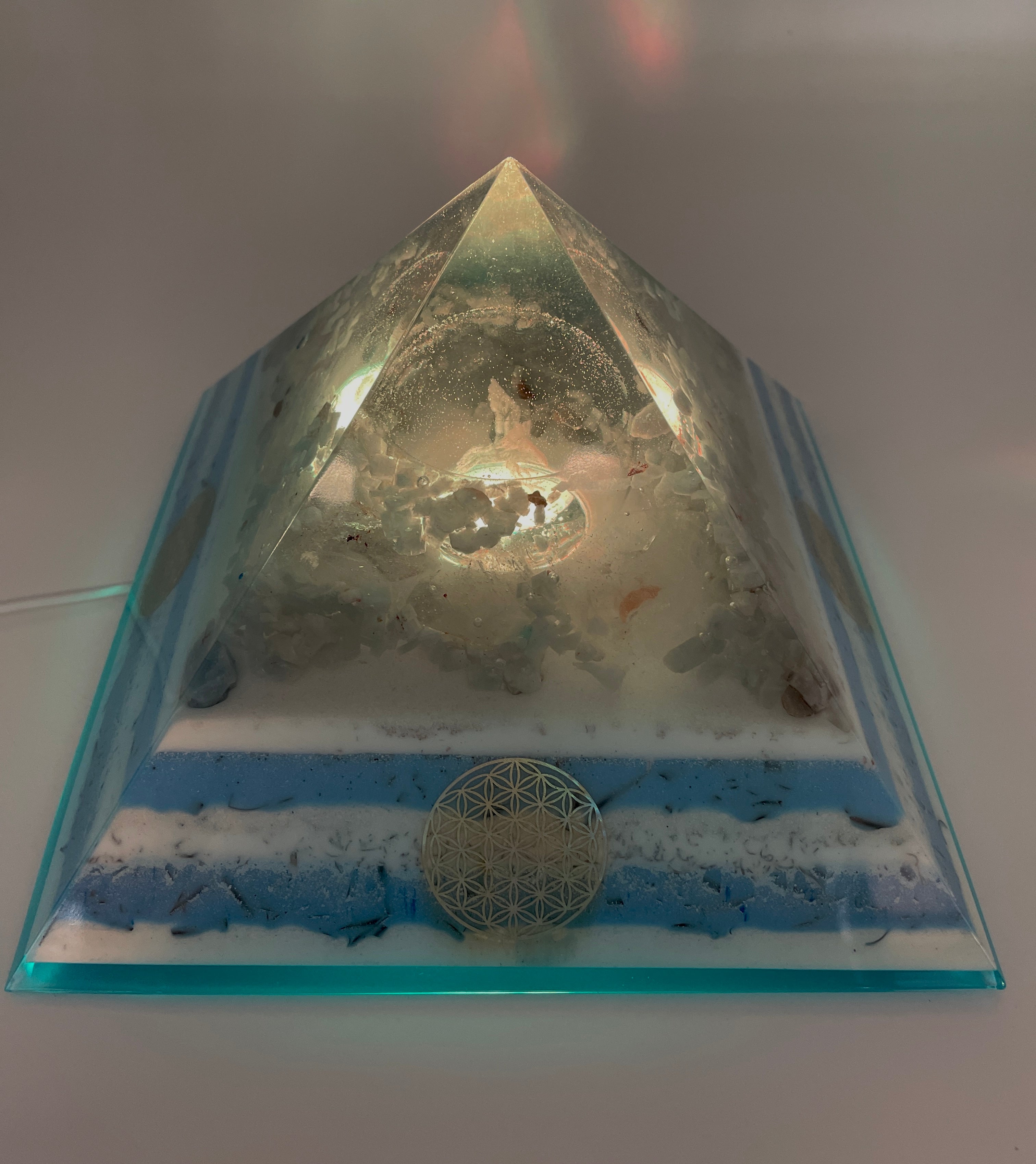 Orgonpyramide mit Blaucalcit und beleuchtetem Adler in Glaskugel