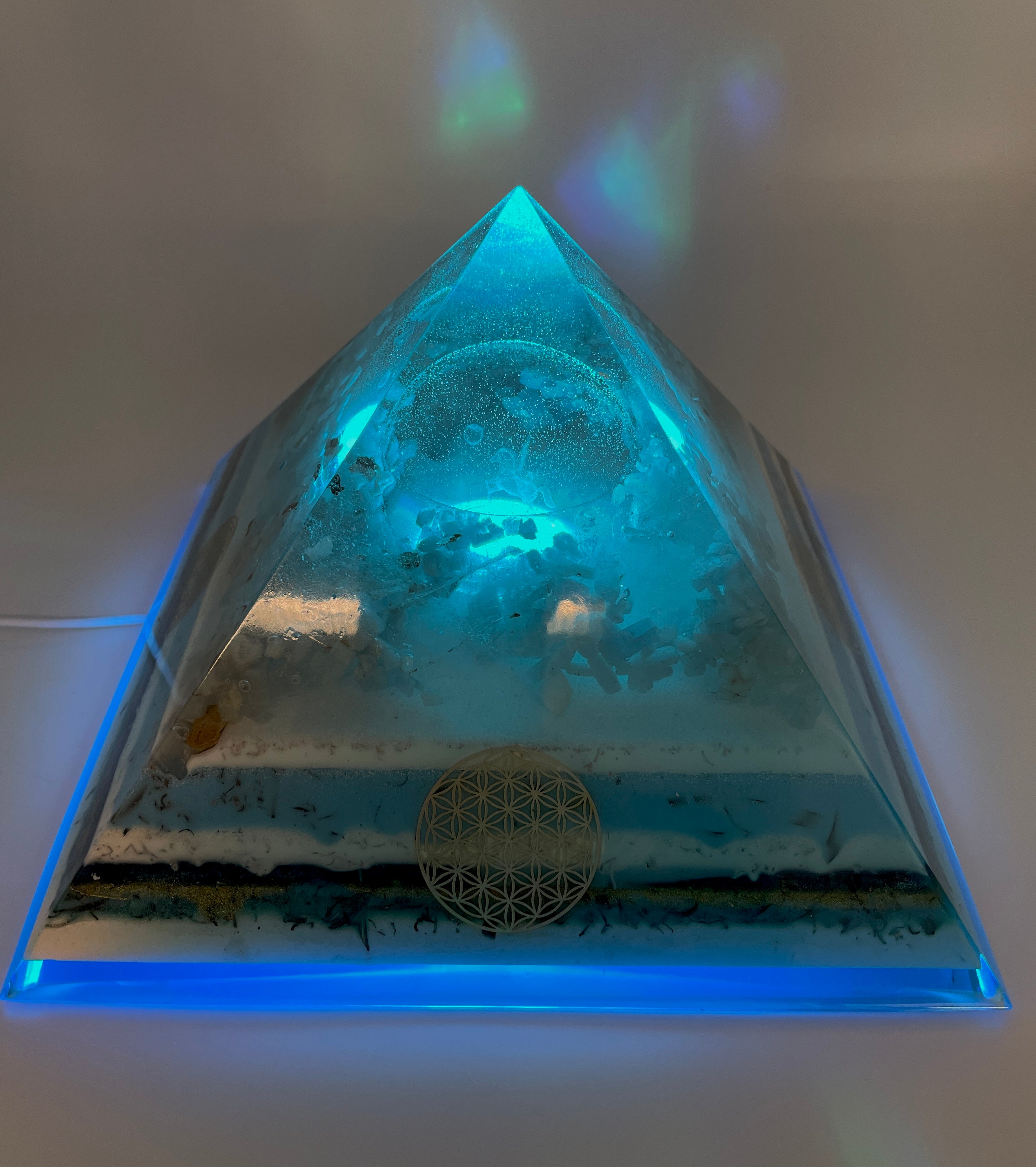 Orgonpyramide mit Blaucalcit und beleuchtetem Pegasus in Glaskugel