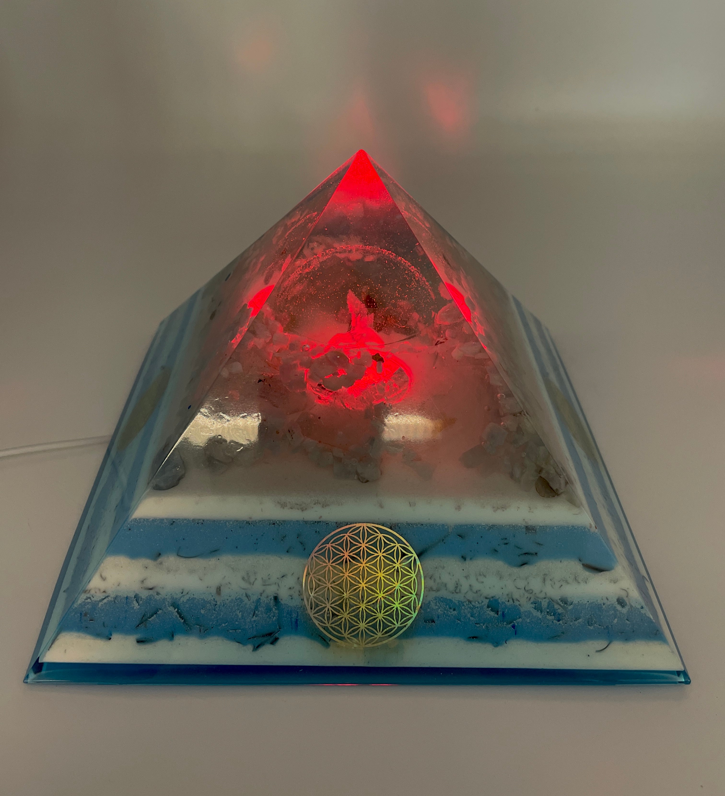 Orgonpyramide mit Blaucalcit und beleuchtetem Adler in Glaskugel