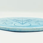 Runde blaue Orgonit-Scheibe mit geometrischem Muster auf weißem Hintergrund